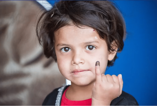 Child receives a purple stain on his pinky to indicate that she has received a polio vaccine.