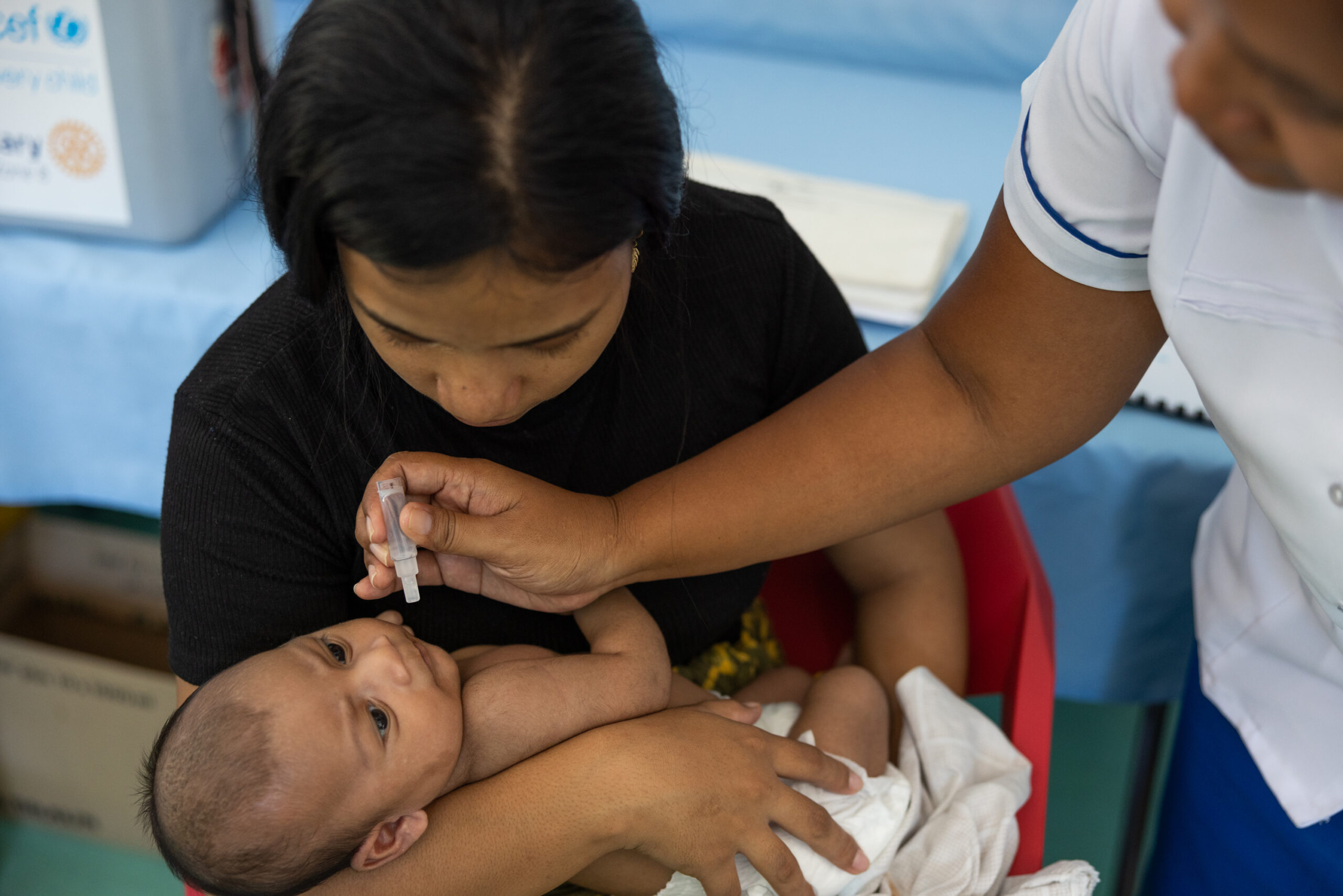 Child receives a purple stain on his pinky to indicate that she has received a polio vaccine.